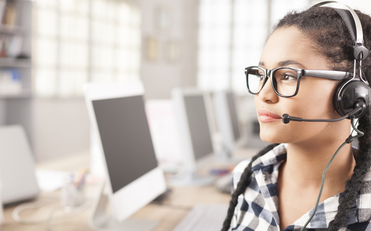 Close-up of young female call center operator with headphones