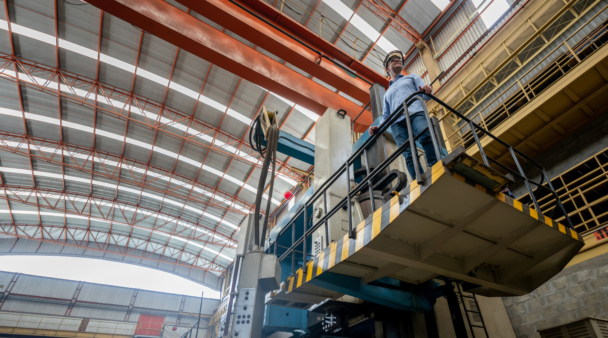 Man working in a metallurgy factory and standing on a forklift