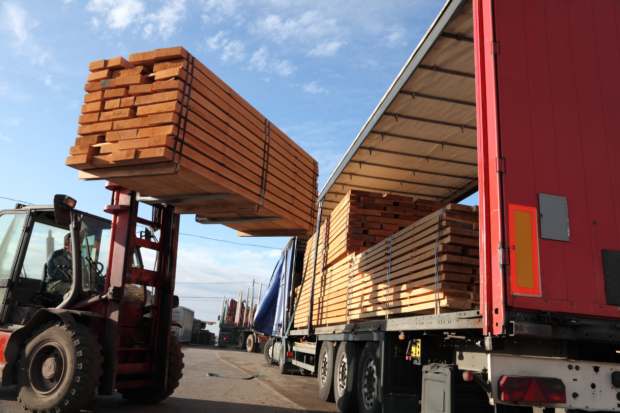 forklift loading lumber into the side of a tractor trailer